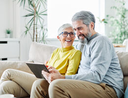 An older couple looks at a tablet together.